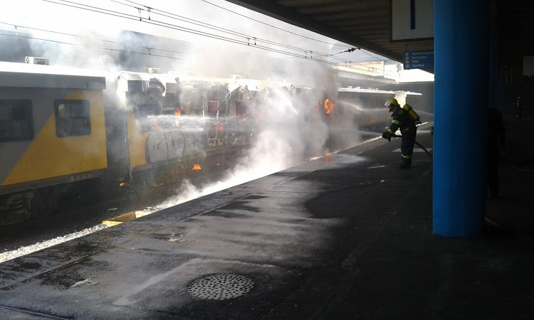 A fireman tackles the burning train at Cape Town station