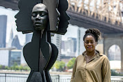 Artist Tanda Francis poses with her sculpture 'Rockit Black' in Queensbridge Park, Queens borough of New York.