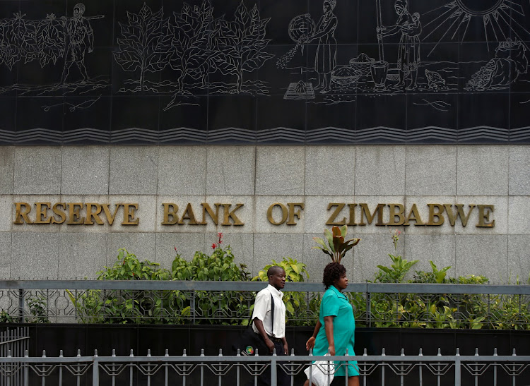 People walk past the Reserve Bank of Zimbabwe building in Harare, Zimbabwe, February 25 2019.