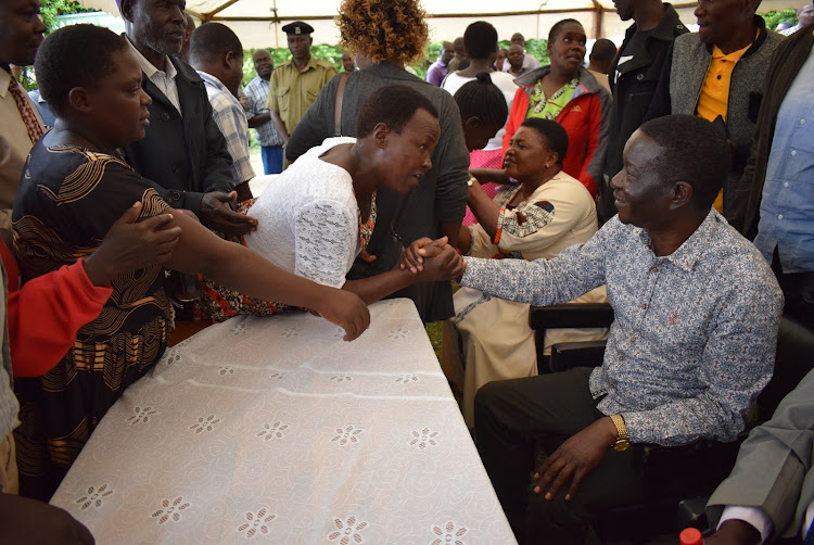 Kasipul MP Ongondo Were greets some parents who came during distribution of bursary cheques to students in Oyugis town on March 13,2023