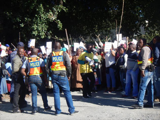 ANGRY: Residents of Mantusini village in PSJ protesting in front of the town's police station demanding the arrest of a police officer who they claim is behind the disappearance of Yvonne Mbekwa who went missing more than a month ago. Picture:SIKHO NTSHOBANE