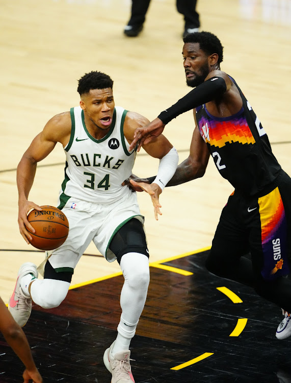 Milwaukee Bucks forward Giannis Antetokounmpo (34) moves the ball against Phoenix Suns center Deandre Ayton (22) during the second half in game one of the 2021 NBA Finals at Phoenix Suns Arena.