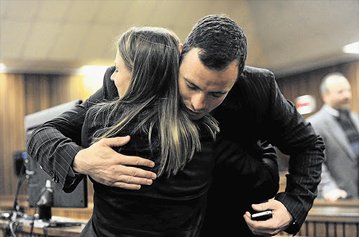 SHOW OF SUPPORT: A hug from a well-wisher for Oscar Pistorius in the Pretoria High Court yesterday. Pistorius is accused of murdering his girlfriend, Reeva Steenkamp, on StValentine's Day last year