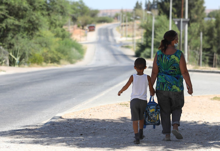 A parent walks her son home from school in Klawer last week. An 11-year-old boy has since gone missing in the West Coast town.