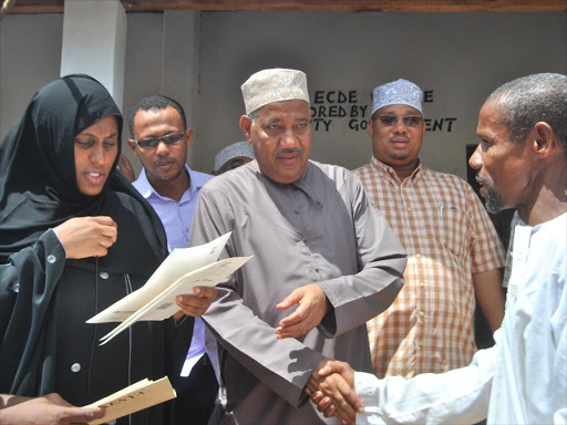 Left to (R) Lamu County Excecutive for Lands Amina Rashid, Lamu Governor Issa Timammy and Lamu east MP Shariff Athman issue tittle deeds.photo/FILE