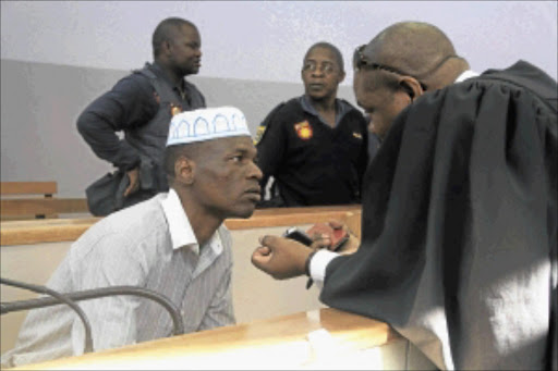 All ears: Chris Mahlangu listens to his attorney in court. PHOTO: Busisiwe Mbatha