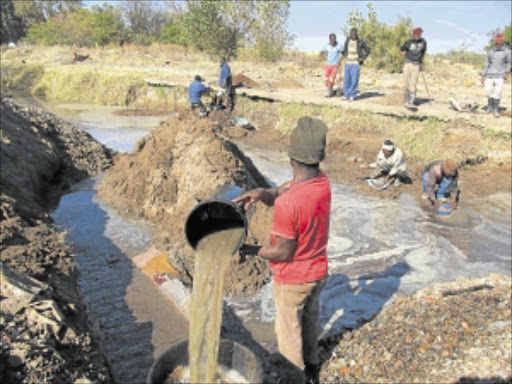 GOLD RUSH: Illegal miners search for gold particles at the closed Bambanani Mine in Welkom. Sixteen suspected gold dealers appeared in the Bloemfontein High Court yesterday. PHOTO: NTWAAGAE SELEKA