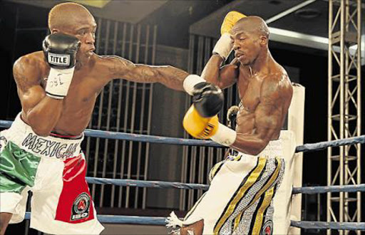 GETTING A HEADSTART: Featherweight champion Lusanda Komanisi, left, in action against Macbute Sinyabi, has joined US promoter’s stable Picture: FILE