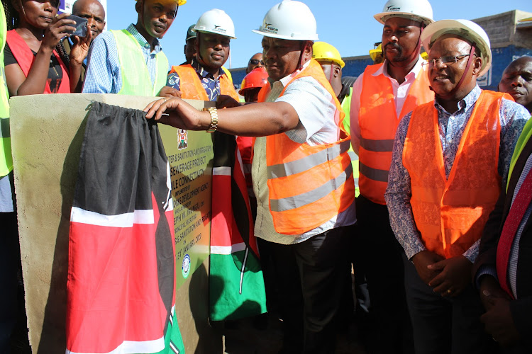 The PS for Water and Sanitation Joseph Irungu commissions the expansion of Othaya sewerage system as MP Gichuki Mugambi (Right) looks on