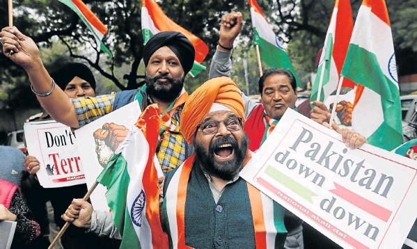 Protesters hold national flags and placards to celebrate India’s airstrikes on militant camps in Pakistani territory, in New Delhi.