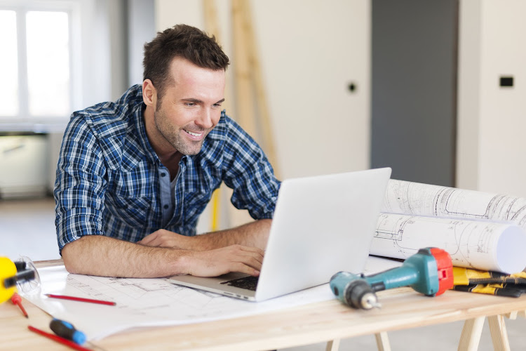 smiling-construction-worker-working-with-laptop.jpg