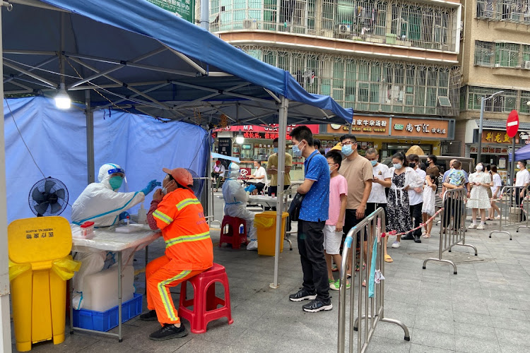 A medical worker in a protective suit collects a swab from a resident at a testing site in Nanshan district in Shenzhen, China, September 1 2022. Picture: DAVID KIRTON/REUTERS