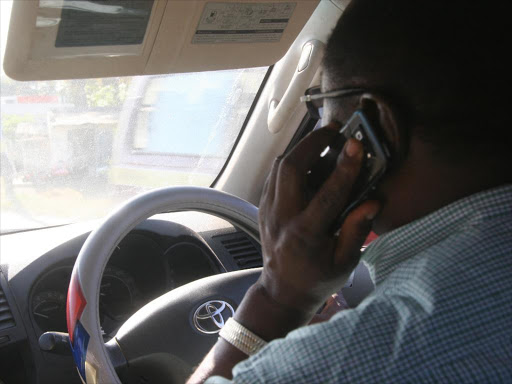 A motorist uses his mobile phone while driving. Photo/ELKANA JACOB