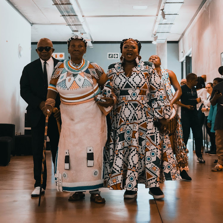 Mmakgabo Helen Sebidi walks with singer Ann Masina at the launch of the Ntlo E Etsamayang (Walking House) exhibition