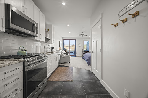 Modern kitchen open to living room and bedroom in this luxury house for sale in Grand Lake ($395,000)