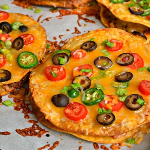 Family friendly Mexican Pizzas stuffed with refried beans and taco seasoned ground beef then topped with oddles of cheese, sun ripened tomatoes and spicy jalapenos.