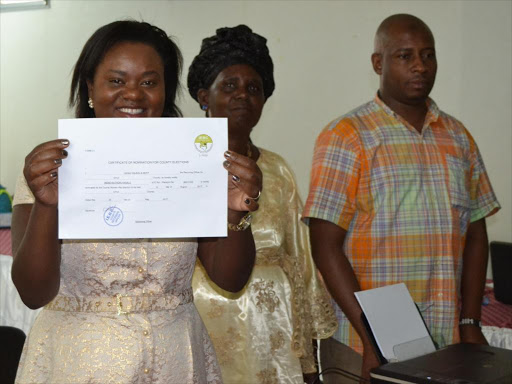 Wiper Candidate for the Kitui Women Represenative seat Irene Kasalu displays her certificate of nomination after she got it from Kitui County Returning Officer Gogo nguma on Tuesday. Photo by Musembi Nzengu