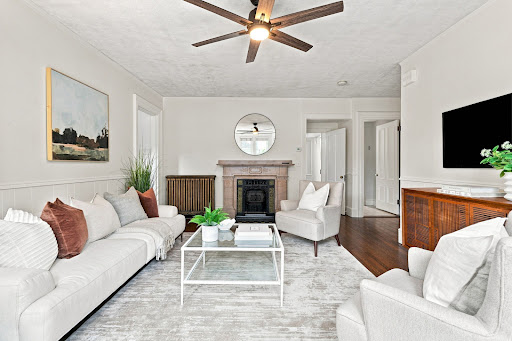 Living room with white sofa and fireplace in this luxury apartment / penthouse for sale in Newton ($795,000)