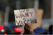 FILE PHOTO: A person holds a placard as supporters of the Economic Freedom Fighters (EFF) march to demand a rollout of coronavirus disease vaccines, in Pretoria, South Africa on June 25, 2021. 
