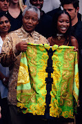 Fashion model Naomi Campbell presents Nelson Mandela with a green Versace shirt. 