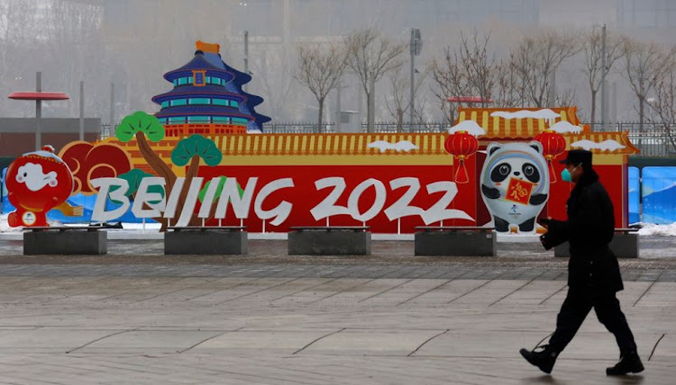 A security guard walks past advertising boards outside the Main Press Centre ahead of the Beijing 2022 Winter Olympics in Beijing, China, January 24, 2022