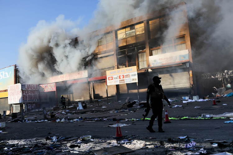 A police officer surveys the aftermath of the unrest. Picture: SIPHIWE SIBEKO