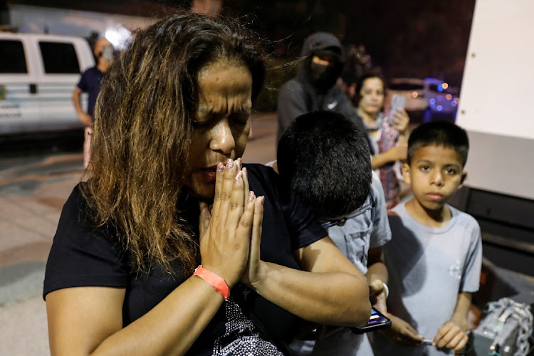 Zulema Perez prays in front of the memorial for victims of a partially collapsed residential building as the emergency crews continue search and rescue operations for survivors, in Surfside, near Miami Beach, Florida, U.S. on June 25, 2021.