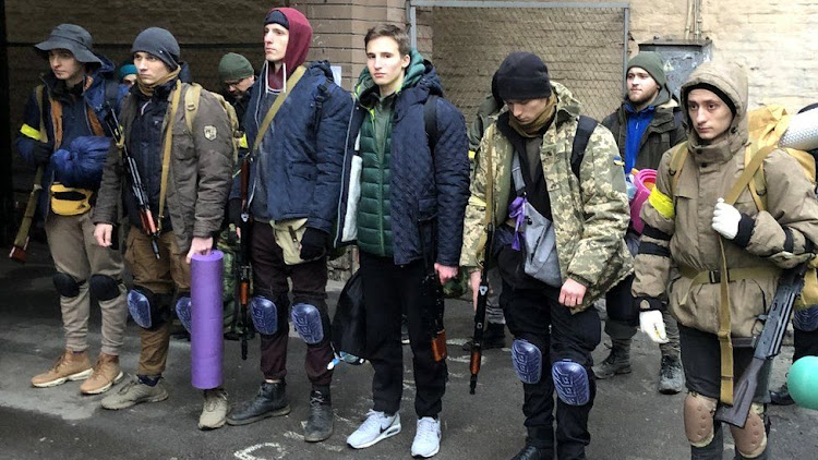 Maksym (far left) and Dmytro (centre, with green jacket and white trainers) before their training