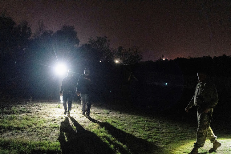 Central American migrants are being escorted by the members of US National Guard after crossing the Rio Grande river into the United States from Mexico in Roma, Texas, US April 28, 2021.