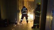 Firefighters had to cut through security barriers to reach an injured man who fell from a burning building in Johannesburg on December 30 2018.