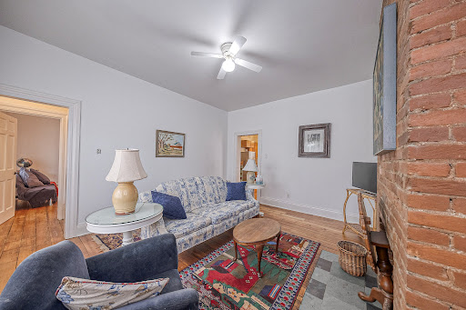 Luxury house for sale in Leetsdale (United States) - Living room with floral sofa and exposed brick