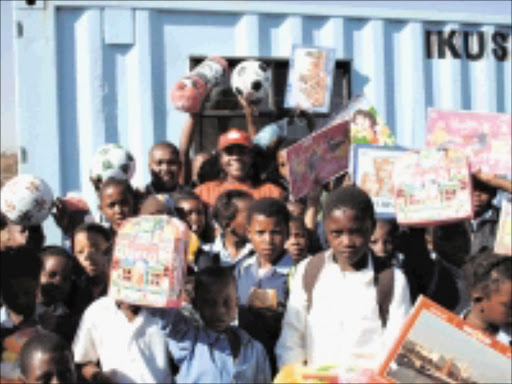 THANK YOU: Mama Angel with some of the children of Freedom Park and the presents that she and Sowetan donated. 09/2008. © Unknown.