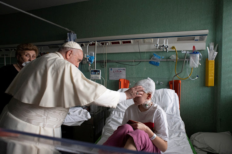 Pope Francis blesses an injured child who fled the Russian invasion of Ukraine, during a visit to the Bambino Gesu Children's Hospital, in Rome, Italy, March 19 2022. File photo.