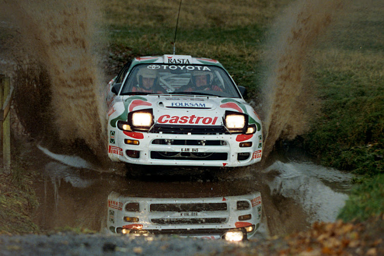 Juha Kankkunen drives his Toyota through a large puddle during the 1993 Rally of Great Britain.