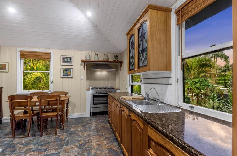 Notice the Art Nouveau leadlight patterns in the furniture and above the doors. The kitchen has timber cabinetry and a freestanding gas cooker.