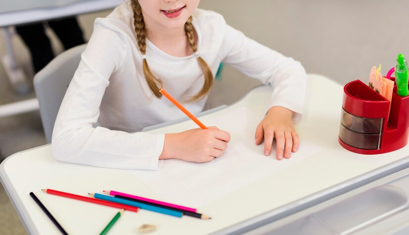 Top view of a girl writing in an empty notebook, highlighting the creative learning experiences in homeschooling.