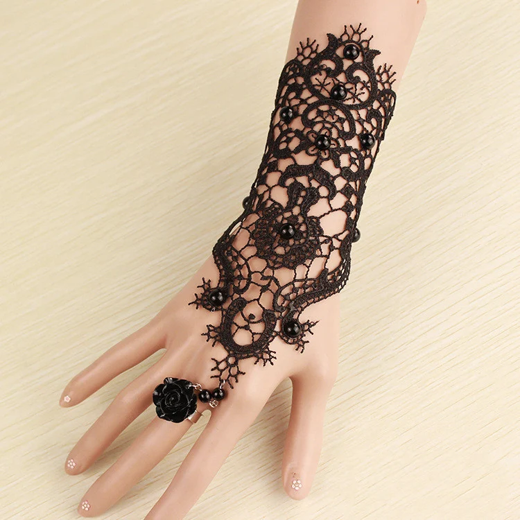 Bracelet en dentelle noire avec anneau et chaîne intégrée un bijou unique pour le poignet et le doigt, parfait pour rehausser une tenue et ajouter une touche d'élégance.