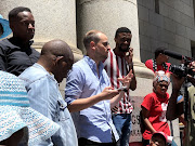 Michael Clarke, lawyer for housing activist organisation Ndifuna Ukwazi, talks to supporters about Monday's court proceedings. 