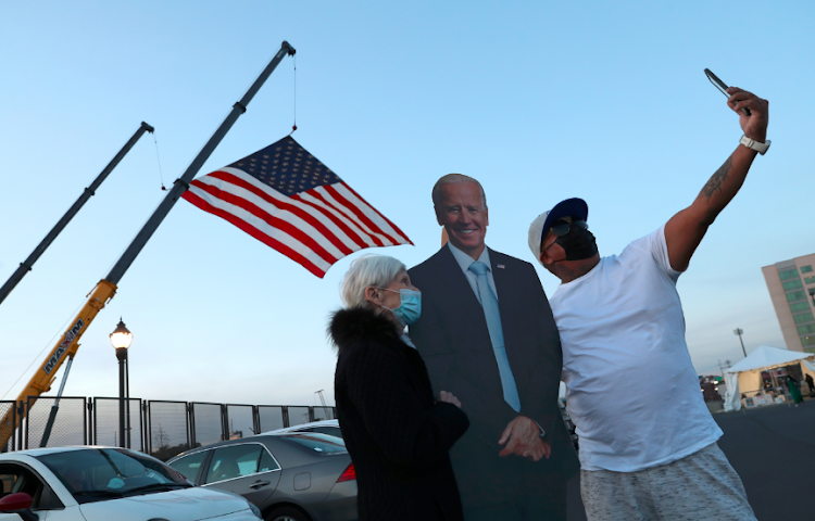 Supporters including Jo Lawlor of Pennsylvania (L) pose for photographs with a cutout of former Vice President Joe Biden near the site where Biden and Senator Kamala Harris hope to celebrate their victory in the US presidential race in Wilmington, Delaware, US on November 5, 2020.