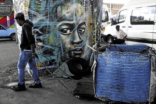 A man pulls a trolley as he makes his way to a recycling place next to Newtown Junction, Johannesburg. The writer says South Africans are depressed by what we believe are our own failures, but we have been trudging through a quagmire of orchestrated inequality and systemic impoverishment since the first colonisers set foot on this land.