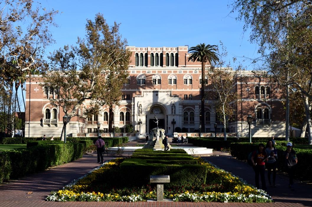 A large building with a fountain and trees

Description automatically generated