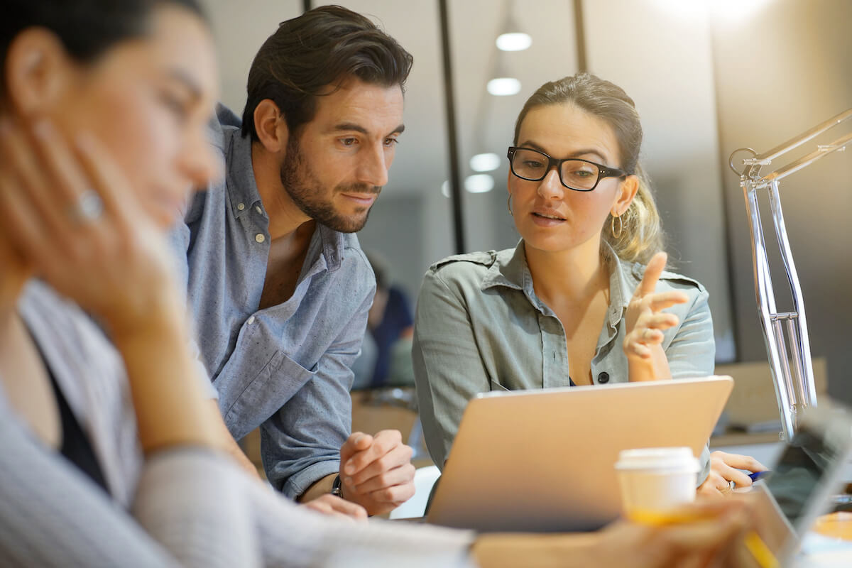 What is human capital management: co-workers discussing something and using a laptop