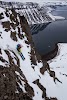 skieër op smalle strook sneeuw op steile helling