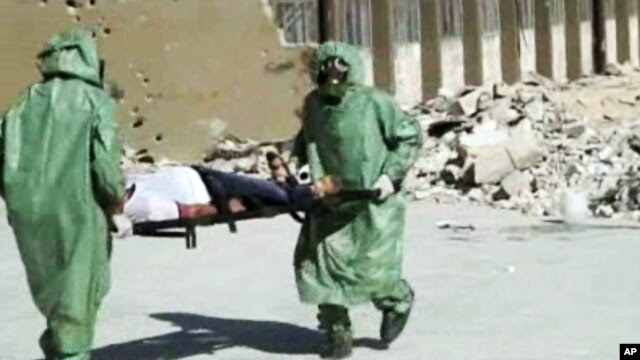 FILE - People in protective suits and gas masks conducting a drill on how to treat casualties of a chemical weapons attack in Aleppo, Syria.