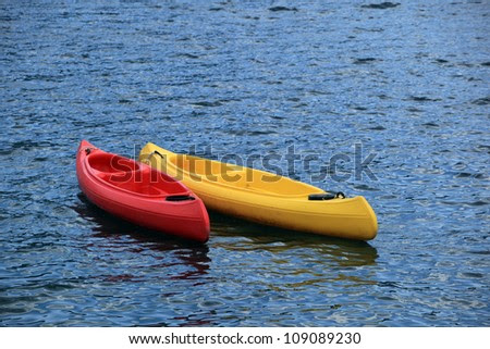 Two fiberglass kayak boat floating on water - stock photo