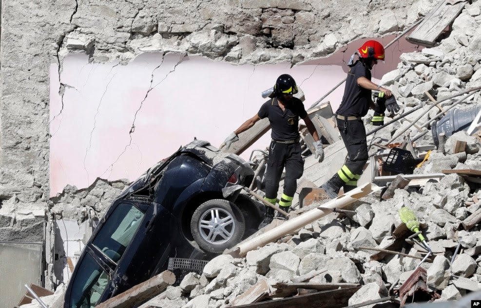 Rescuers make their way through destroyed houses following Wednesday&#39;s earthquake in Pescara Del Tronto, Italy, Aug. 25, 2016.