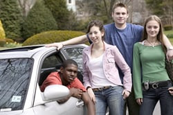 Photo: Teenagers standing around a car