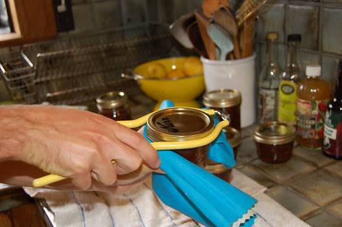 My husband tightening the lids on the jars of loquat chutney before they go into the canner