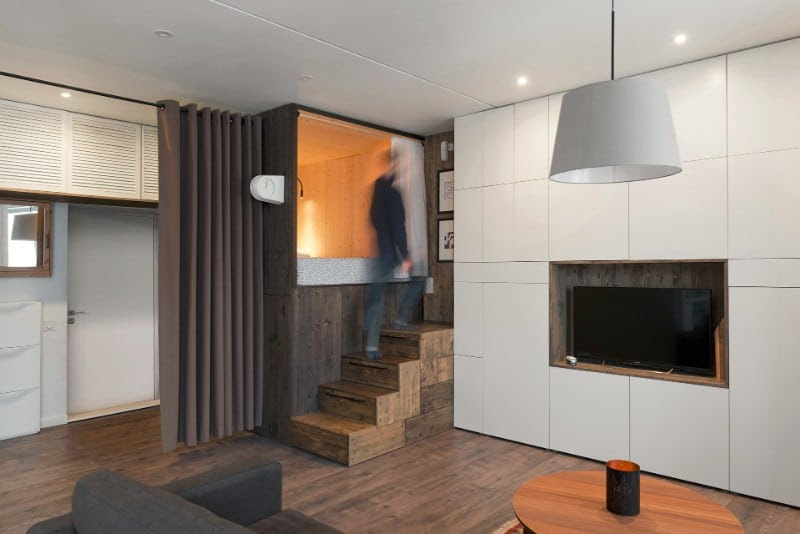 The designer's small studio apartment features an ingenious loft ...  The wooden loft bed with built-in storage is placed in a corner of the  apartment. It provides privacy by separating the sleeping quarters from the  living ...