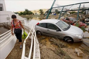 Una mujer pasa junto a varios vehículos arrastrados por las lluvias torrenciales caídas en las últimas horas en la localidad almeriense de Vera.EFE